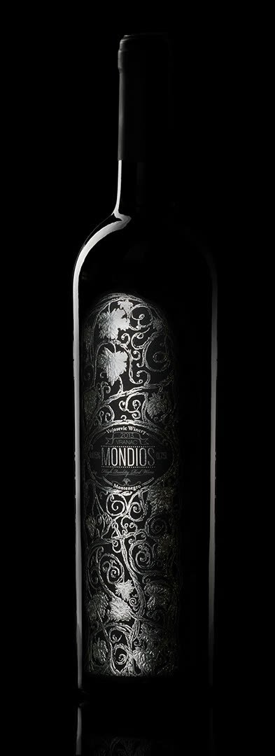Mondios Vranac bottle, silver-etched label lit against black
